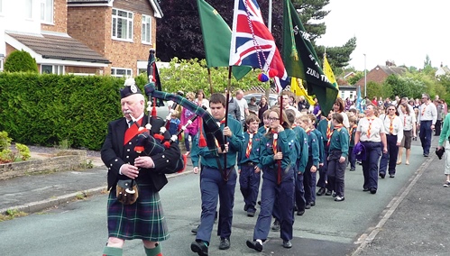 Scottish Piper Reg Flower leads the procession through Wistaston