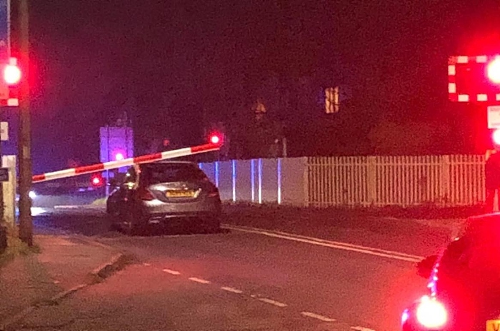 car wedged under level crossing barrier London Rd