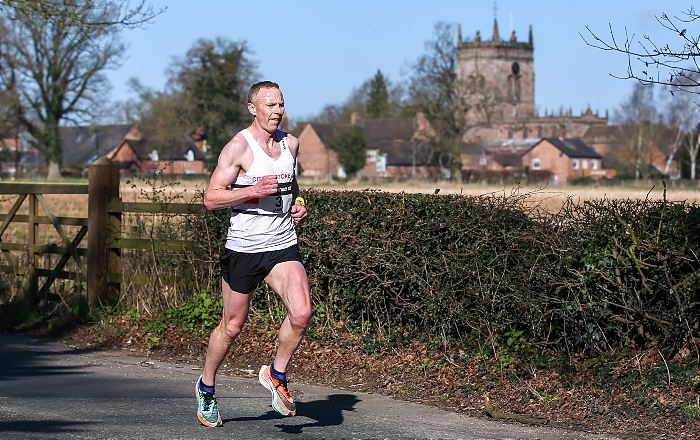Nantwich 10K road race winner - Jamie Arnold - with St Mary's Acton in the background (1)