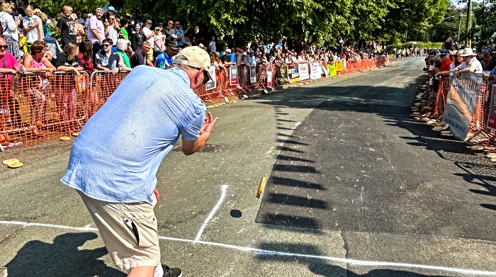 A participant in the Adult race rolls his pie down the hill (1)