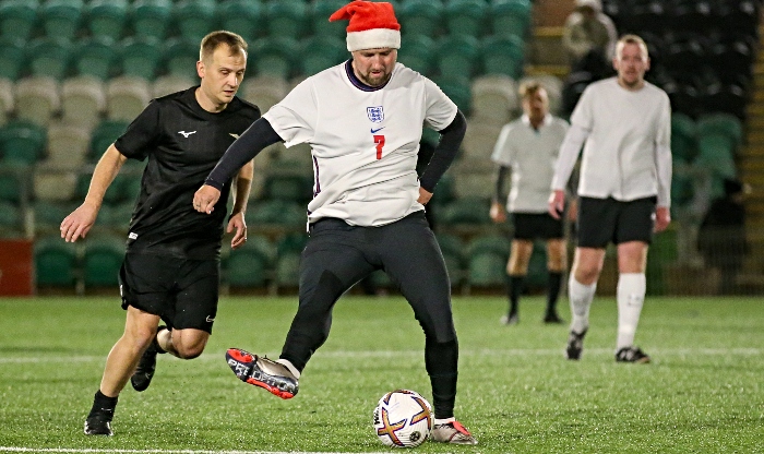 Charity football match - Santa hat wearing player on the ball (1)