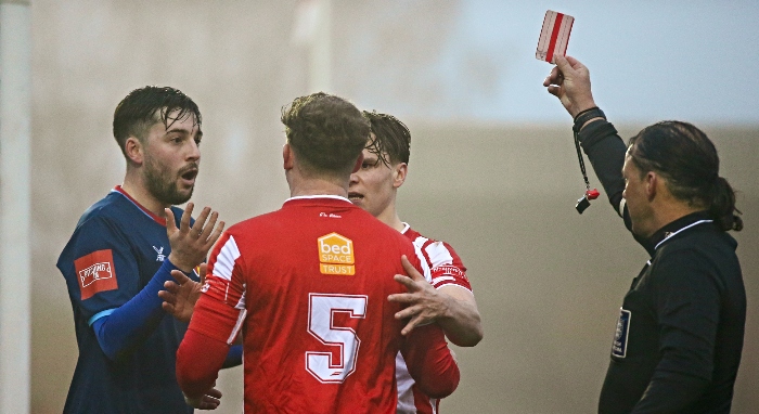 First-half - Callum Saunders (left) receives his red card from the referee (1)