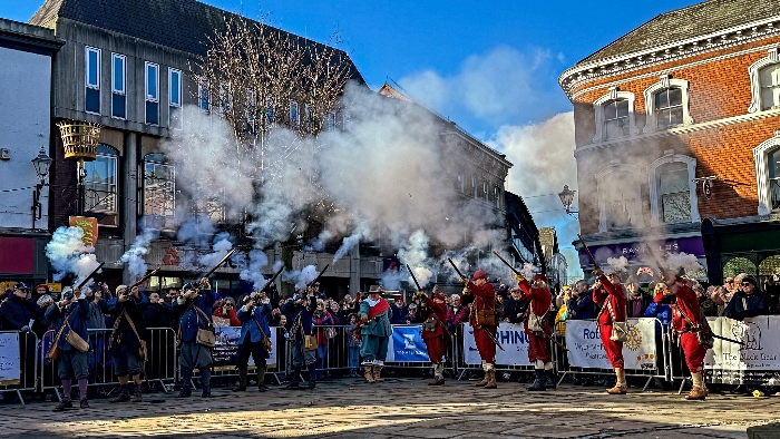 Musketeers fire in unison into the air after the ceremony on the town square (1)