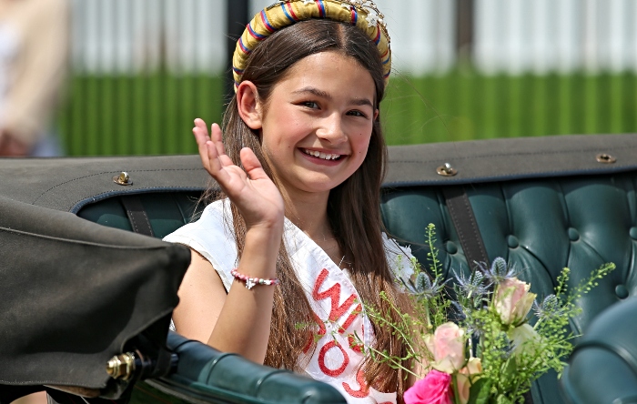 Retiring Rose Queen Lucia Kemp waves to the crowd from a vintage Rover tourer during the parade
