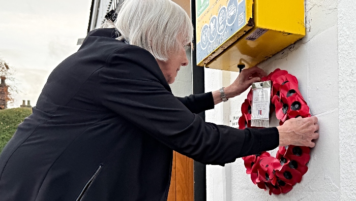 Eileen Bamber, Hall President, places a poppy wreath at the front of the Hall (1)