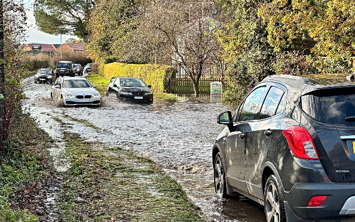 Motorists travel through the floodwaters and pass the stranded motorist today (Sun 16-11-25) (1)