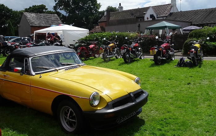 A classic car and motorbikes on display