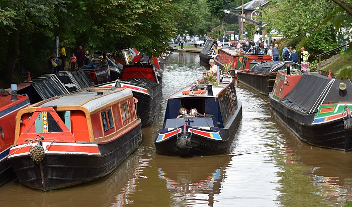 A narrowboat passes historic boats on the Shropshire Union Canal