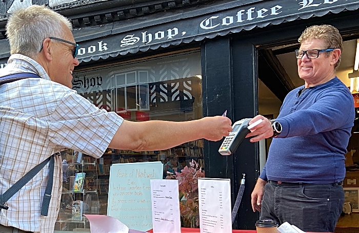 Pandemic - Customer Mark Ray gives a contactless payment to Steve Lawson at Nantwich Bookshop and Coffee Lounge (1)