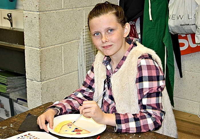 Grace Broad concentrates on painting her Pizza box