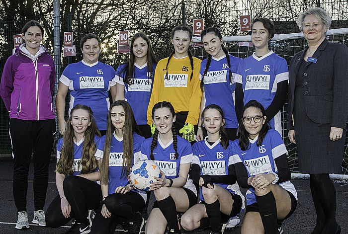 Laura Jones (back left) a teacher at Brine Leas School and Anwyl Homes Jan Smith (back right) with pupils wearing their new football kits