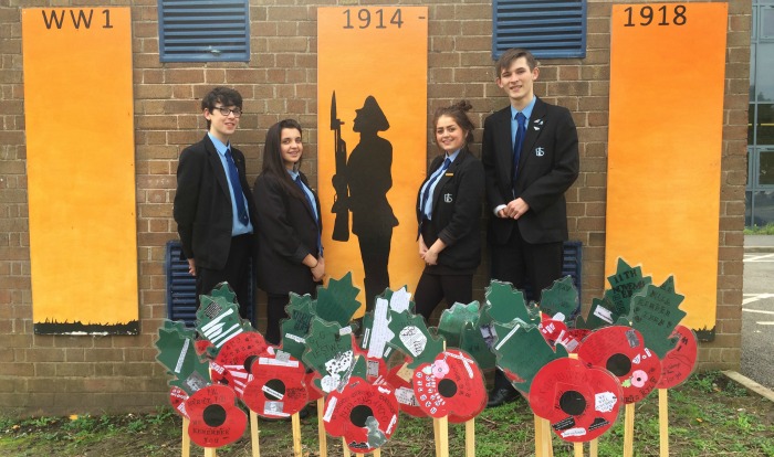 Lewis Tulloch, Ellie Ford, Chelsea Watton and Will O'Connor standing in front of the permanent WW1 memorial, where earlier in the year poppies did bloom.