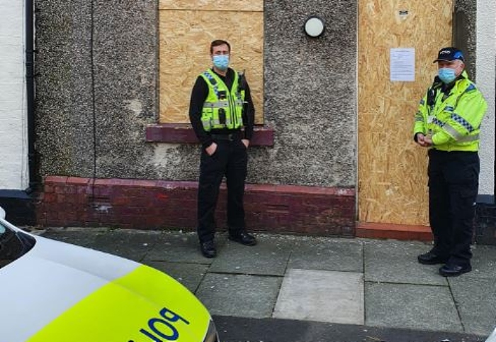 county lines - PC Ian Harrison, left, and PCSO Stephen Marnick outside the house in Bower Street, Widnes, that has been closed for three months (1)