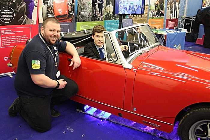 Careers - Simon Bishop is happy to be allowed to sit in the driving seat of a renovated 'Midget' as the process was explained to him by John Brookfield from Reaseheath College Motor Vehicle department