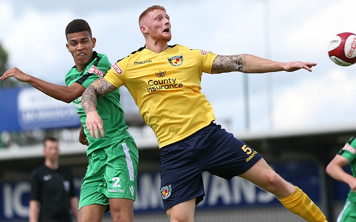 Troy Bourne in green fights for the ball