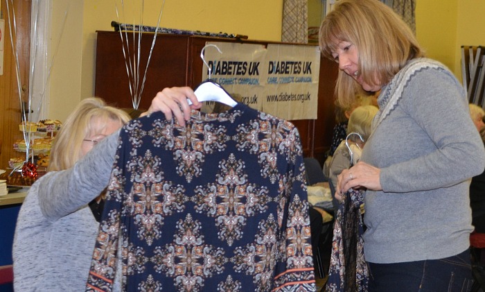 Wistaston Rose Queens Fashion Show and Sale - a garment is inspected